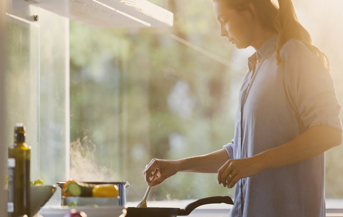 Kvinna lagar mat i ett kök