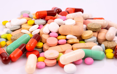 En närbild på en hög med tabletter i olika färger.