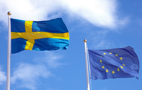 En svenska och en EU flagga mot en blå himmel.