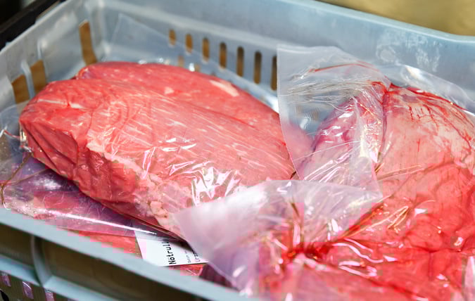 Inplastade köttbitar i tråg