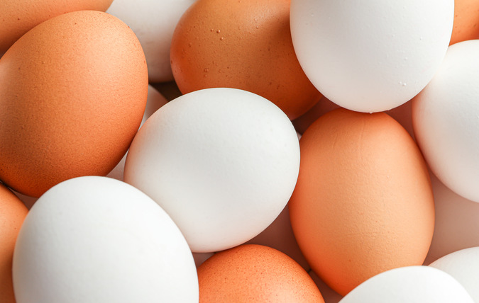 Närbild på massor av vita och bruna ägg