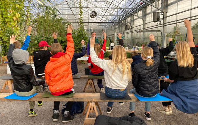 Elever får undervisning i ett växthus.