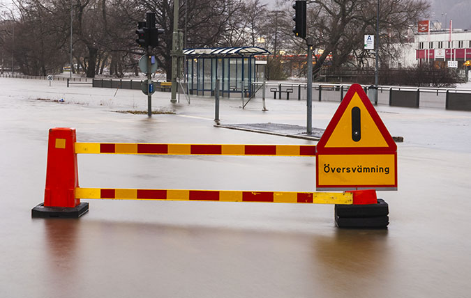 Avspärrning med varningsskylt vid översvämmad gata
