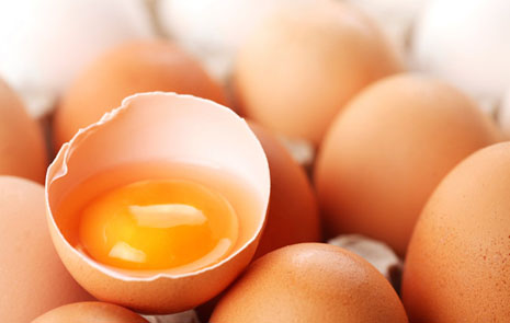 Råa ägg där ett är öppet och visar gulan