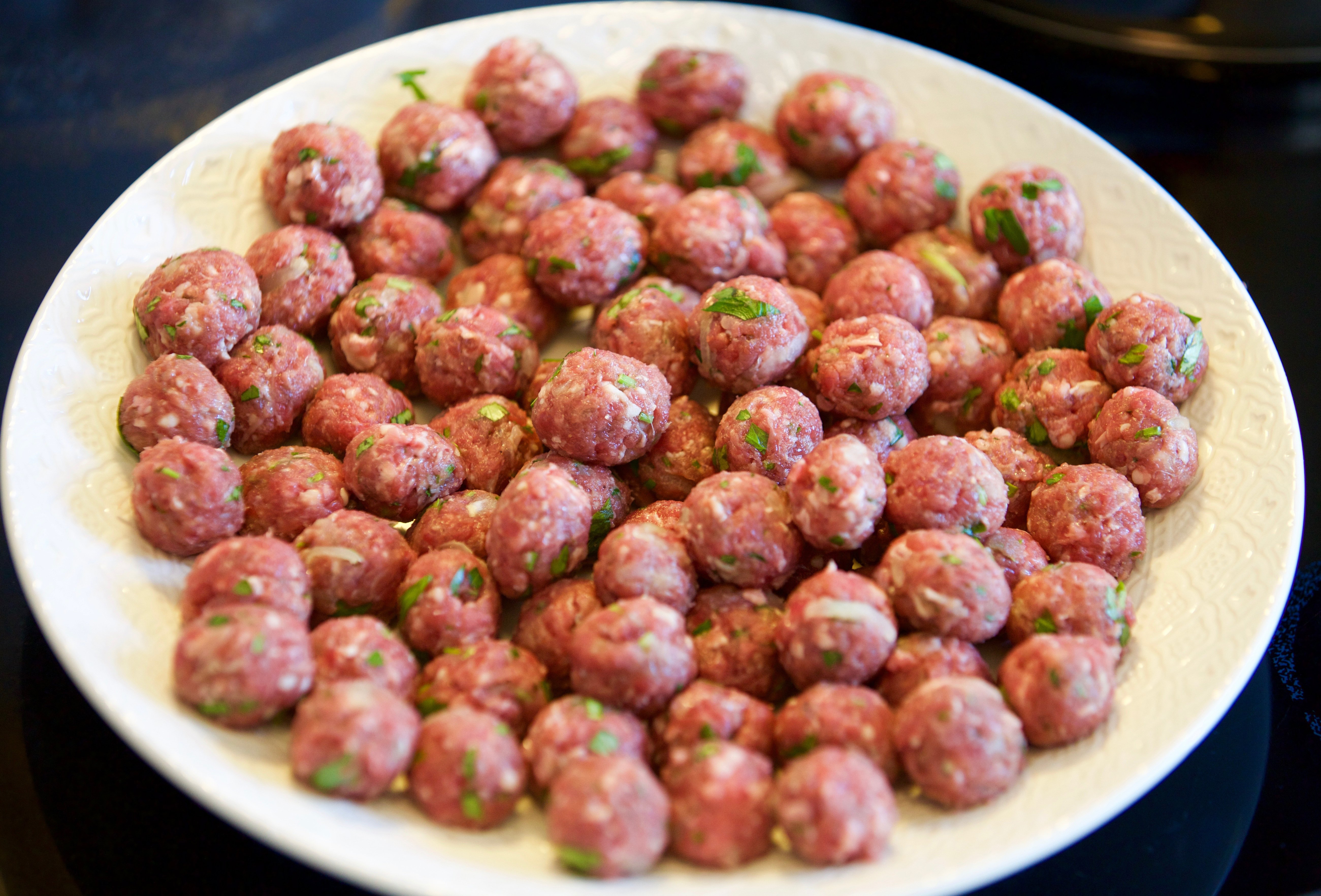 Ostekta köttbullar som ligger på en vit tallrik