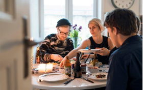 Måltidsmiljö med personer som äter mat och dricker öl.