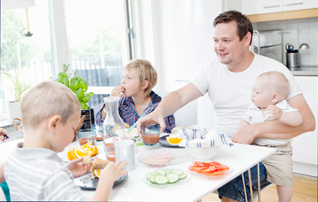 Familj som äter kring köksbordet