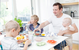Familj som äter kring köksbordet