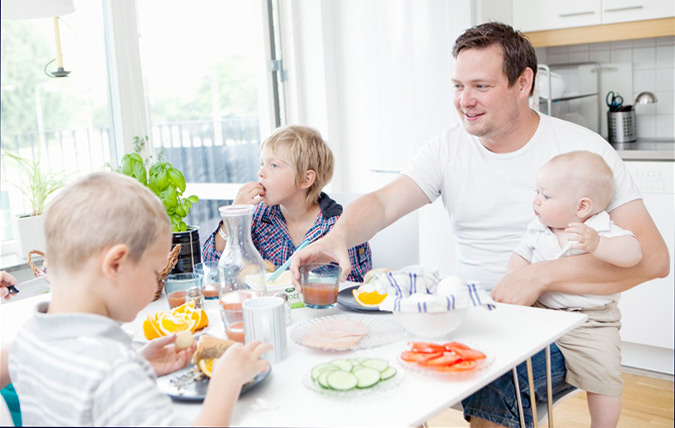Familj som äter mat vid köksbordet