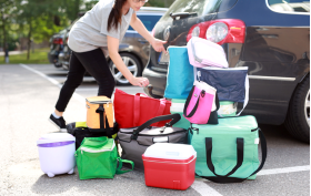 Kvinna packar in kylväskor i bilen